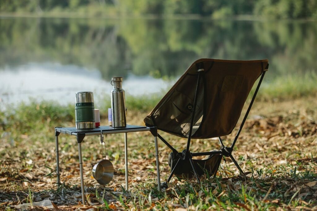 A camping chair with a cup of water and a bottle of water.